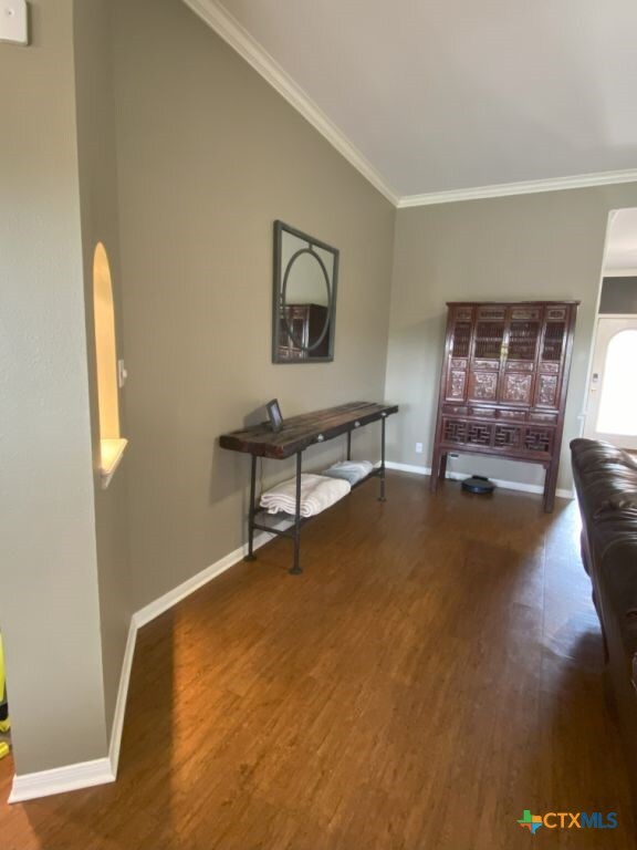 406 Windy Way Dr, Victoria, TX 77904 - living area featuring wood finished floors, crown molding, and arched walkways