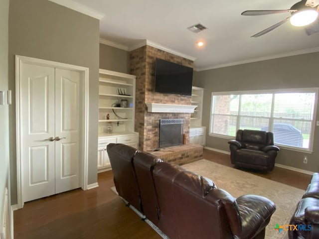 406 Windy Way Dr, Victoria, TX 77904 - living area with dark wood-type flooring, healthy amount of natural light, crown molding, ceiling fan, and a brick fireplace