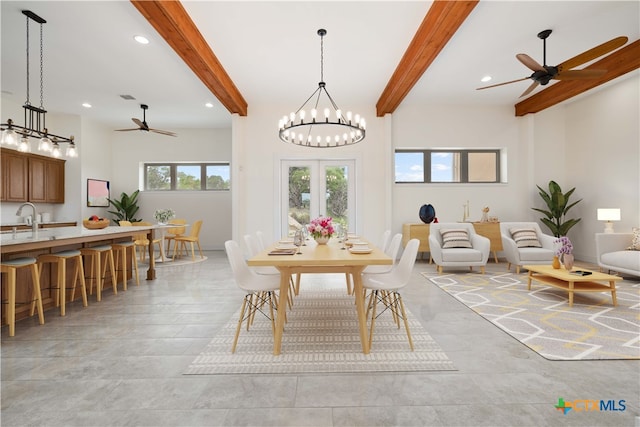 dining room with a high ceiling, beamed ceiling, sink, and ceiling fan with notable chandelier