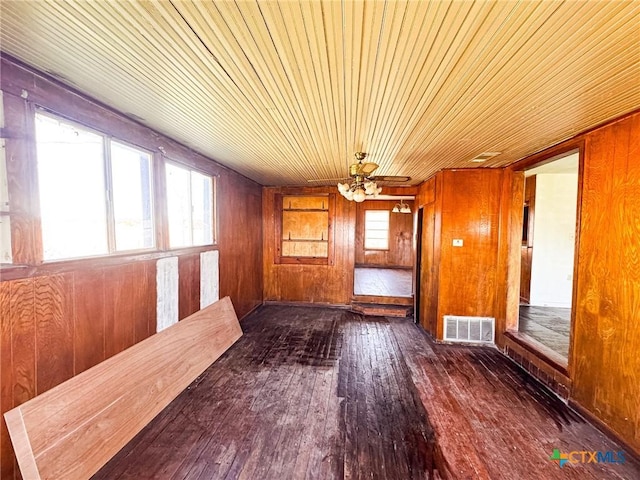 interior space with wood walls, dark hardwood / wood-style flooring, and plenty of natural light