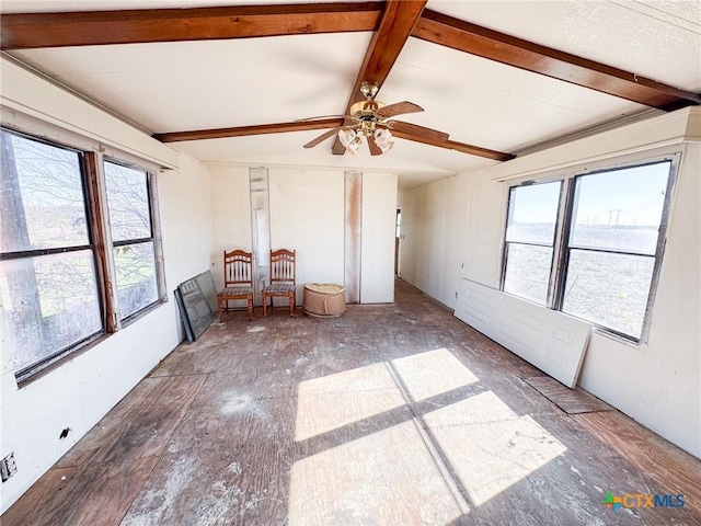 unfurnished sunroom featuring beam ceiling, a wealth of natural light, and ceiling fan