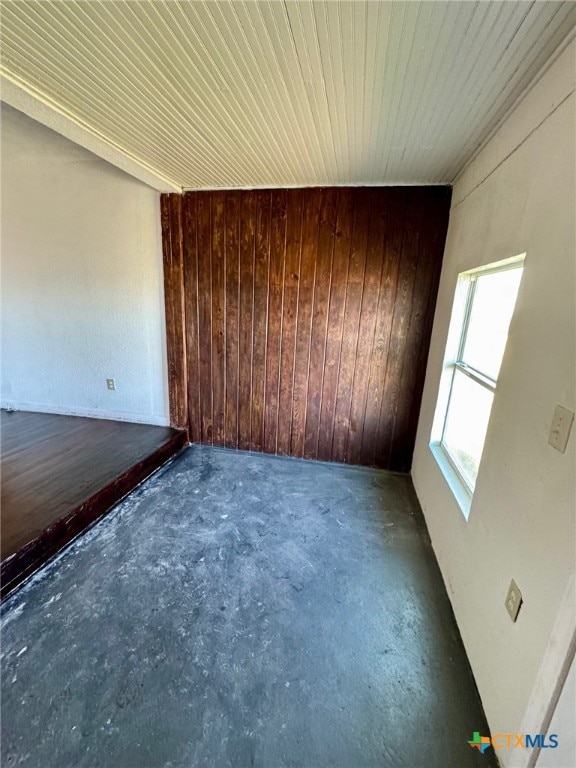 spare room featuring wooden walls