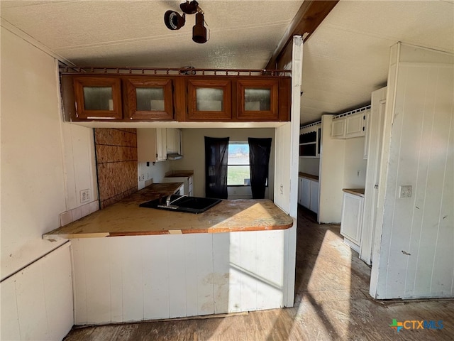 kitchen featuring hardwood / wood-style flooring, wood walls, and sink