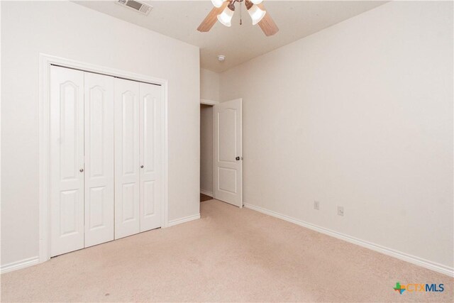 unfurnished bedroom with ceiling fan, carpet, baseboards, visible vents, and a closet