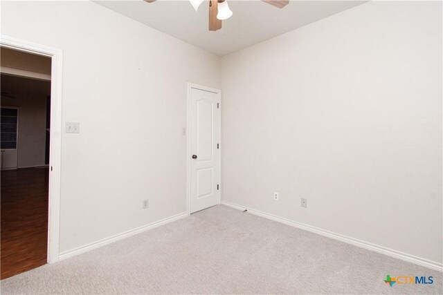 spare room featuring ceiling fan, baseboards, and carpet