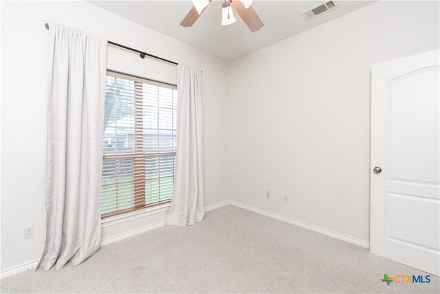 spare room featuring visible vents, carpet flooring, baseboards, and ceiling fan