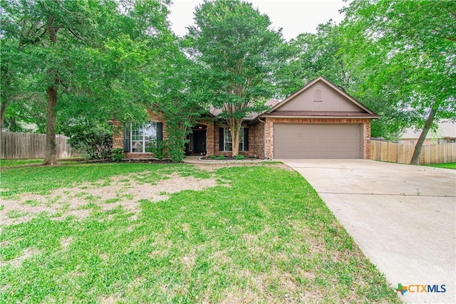 view of front of home with fence, an attached garage, brick siding, a front yard, and driveway