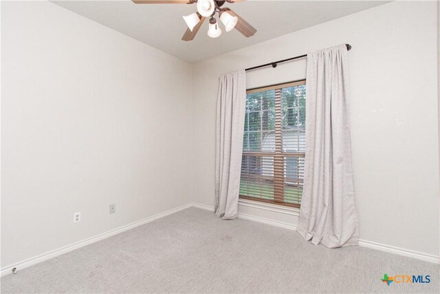 empty room with baseboards, ceiling fan, and carpet flooring