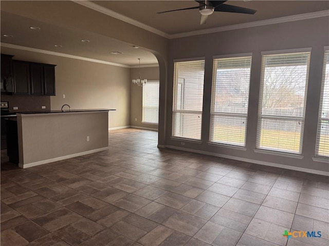 unfurnished living room featuring plenty of natural light, baseboards, and ornamental molding