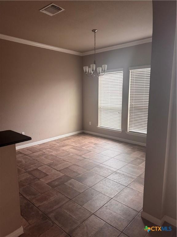 empty room featuring a notable chandelier, visible vents, crown molding, and baseboards