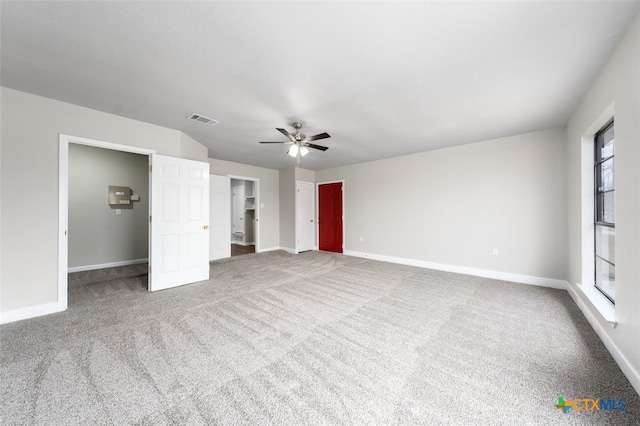 unfurnished bedroom with ceiling fan, a closet, a walk in closet, and carpet