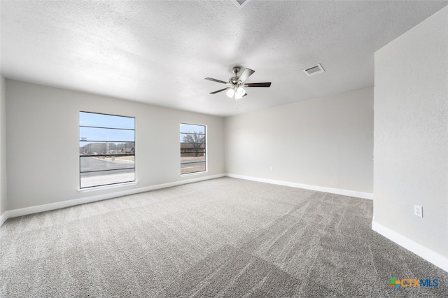 unfurnished room with ceiling fan, a textured ceiling, and carpet floors