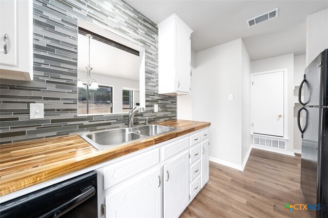 kitchen with white cabinetry, sink, refrigerator, wood counters, and black dishwasher