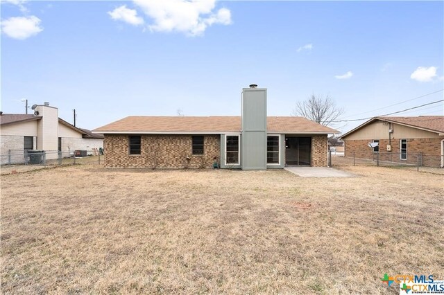 back of property featuring a patio area and a lawn