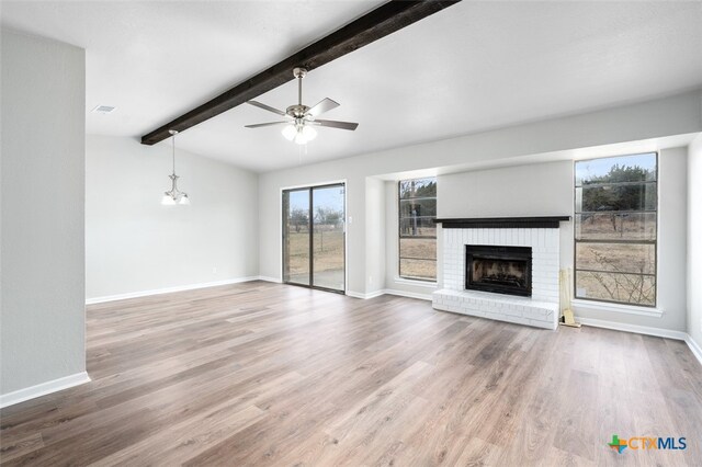 unfurnished living room featuring hardwood / wood-style floors, ceiling fan, vaulted ceiling with beams, and a brick fireplace