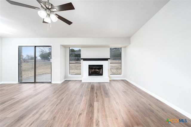 unfurnished living room featuring a fireplace, hardwood / wood-style flooring, and ceiling fan