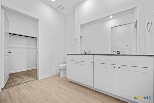 bathroom featuring toilet, hardwood / wood-style flooring, and vanity