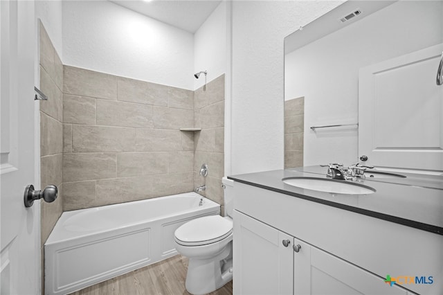 full bathroom featuring toilet,  shower combination, vanity, and wood-type flooring