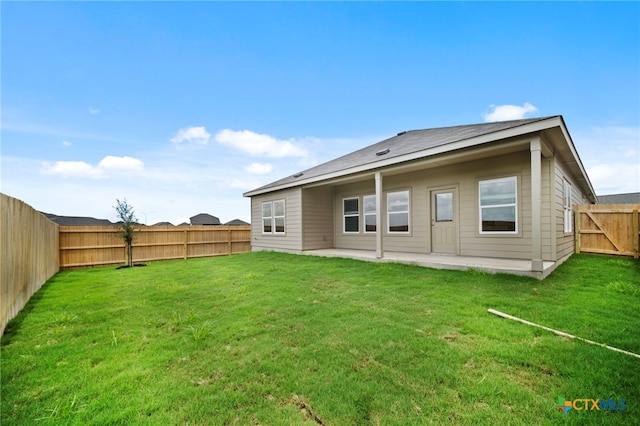 back of house featuring a yard and a patio