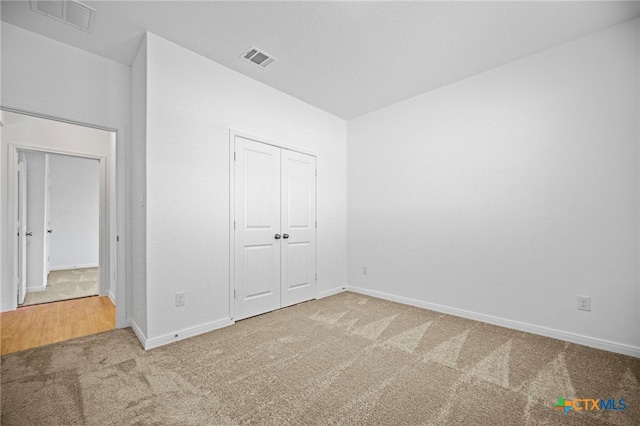 unfurnished bedroom with carpet and a closet