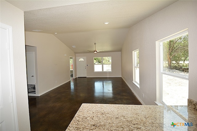 unfurnished living room featuring ceiling fan, lofted ceiling, and a textured ceiling