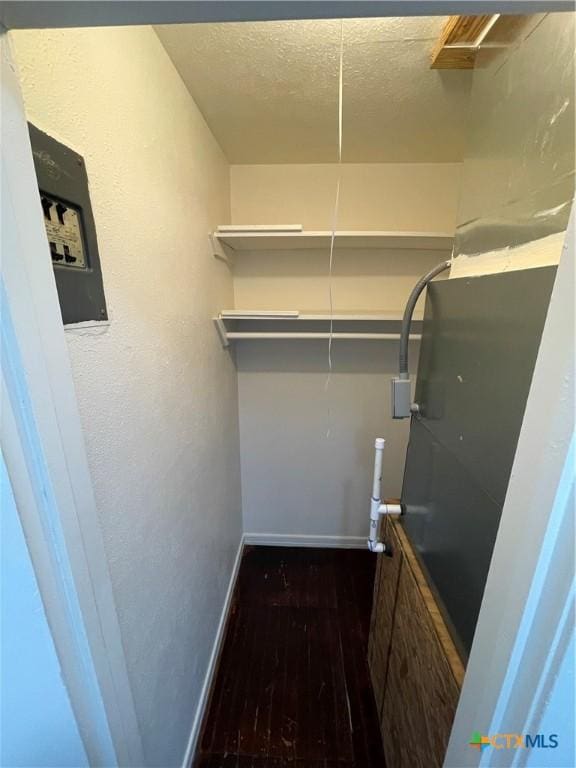 interior space featuring a textured ceiling, baseboards, and wood finished floors