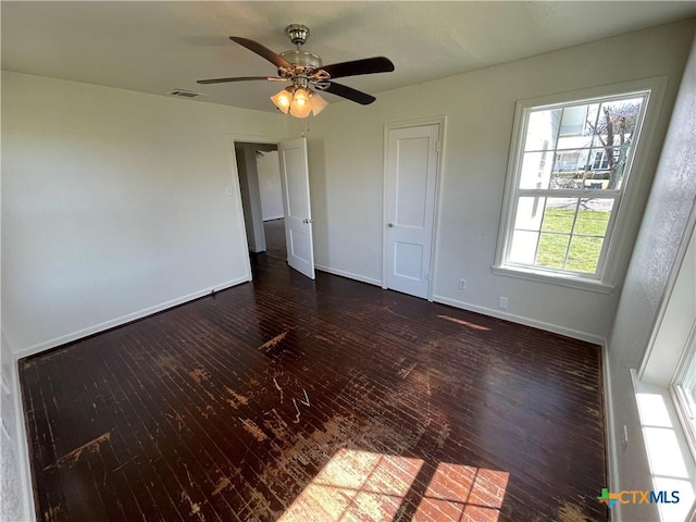 unfurnished bedroom featuring visible vents, ceiling fan, baseboards, and wood finished floors