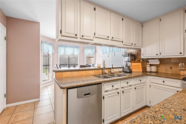 kitchen with light tile patterned floors, white cabinetry, a peninsula, a sink, and dishwasher