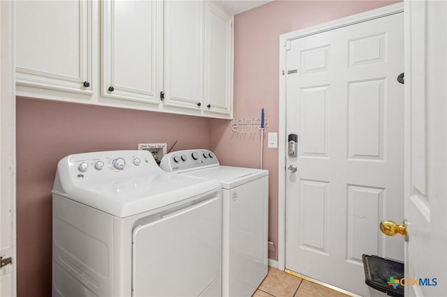 clothes washing area featuring light tile patterned flooring, cabinet space, and separate washer and dryer