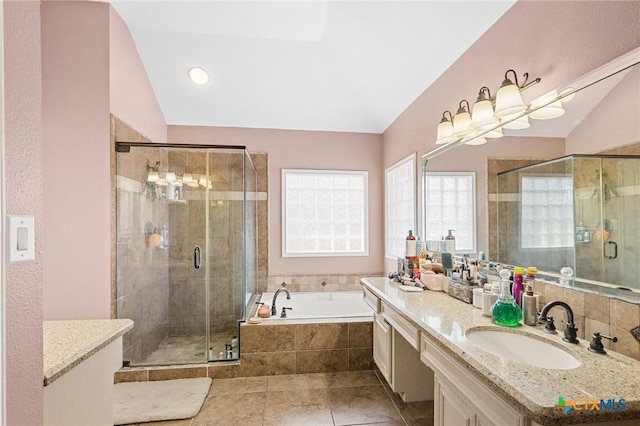 bathroom with vanity, lofted ceiling, a bath, and a stall shower