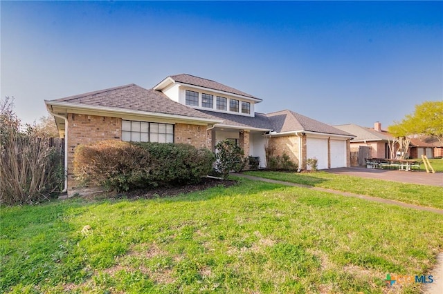 view of front facade with aphalt driveway, a shingled roof, an attached garage, a front yard, and brick siding