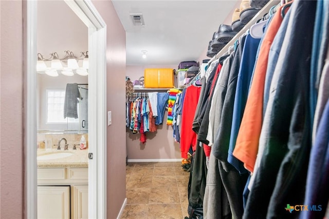 walk in closet featuring a sink and visible vents