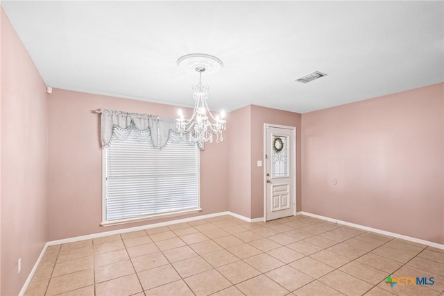 spare room with light tile patterned floors, a notable chandelier, baseboards, and visible vents