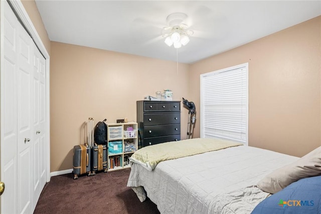 bedroom with a closet, baseboards, ceiling fan, and dark carpet