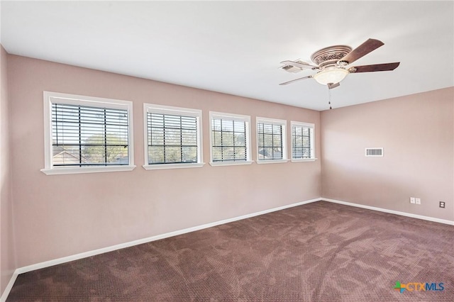 empty room with carpet flooring, baseboards, visible vents, and ceiling fan