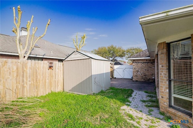 view of yard featuring a patio, an outbuilding, a fenced backyard, and a shed