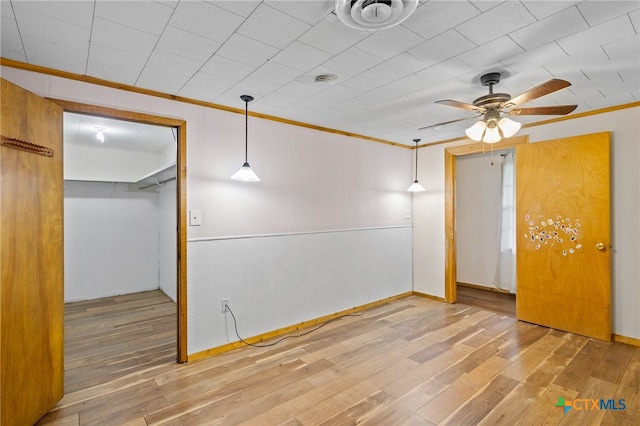 unfurnished bedroom featuring ornamental molding, hardwood / wood-style flooring, ceiling fan, and a closet