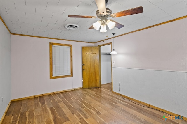 empty room featuring hardwood / wood-style flooring, ceiling fan, and crown molding