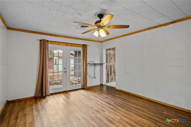 empty room with ceiling fan, wood-type flooring, crown molding, and french doors