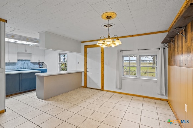 kitchen with wood walls, a wealth of natural light, decorative backsplash, and kitchen peninsula