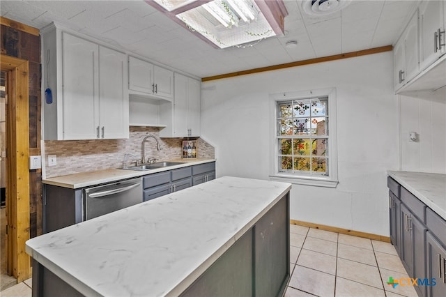 kitchen featuring dishwasher, sink, gray cabinetry, and light tile patterned floors