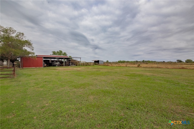 view of yard with an outdoor structure and a rural view