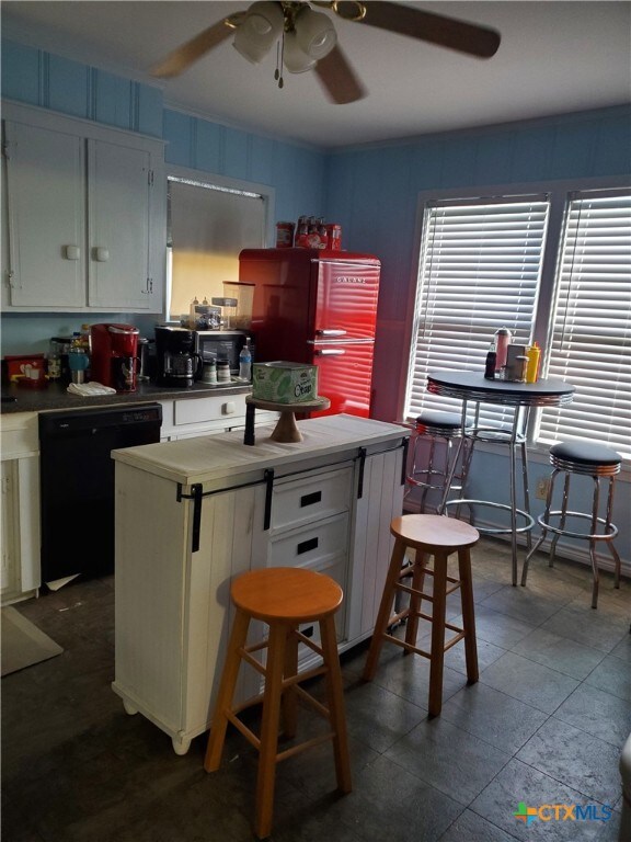 kitchen with a center island, white cabinets, dishwasher, ceiling fan, and stainless steel refrigerator