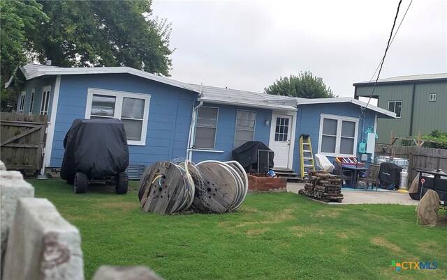 back of property featuring a patio and a lawn