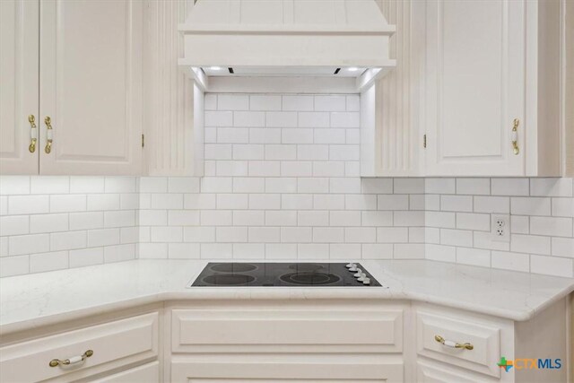 104 Twelve Oaks Dr, Temple, TX 76504 - kitchen with tasteful backsplash, white cabinets, light countertops, premium range hood, and black electric stovetop