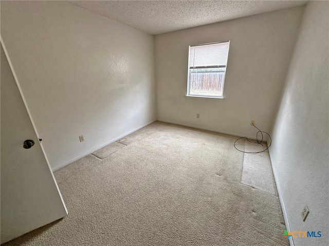 empty room featuring a textured ceiling and carpet flooring