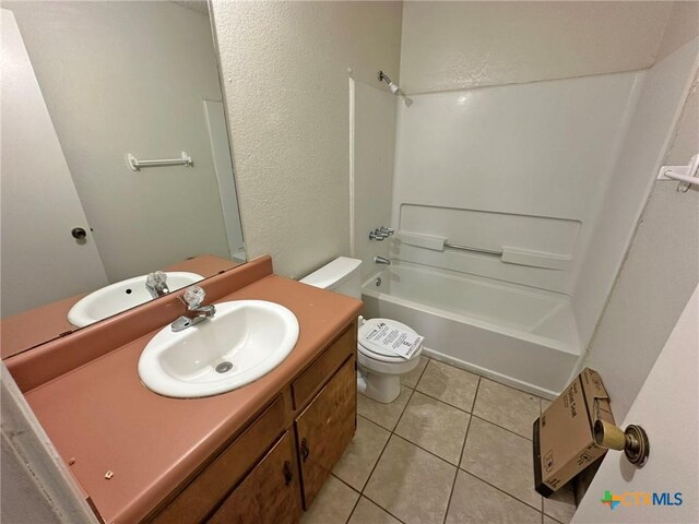 full bath featuring a textured wall, toilet, tile patterned flooring, vanity, and shower / bathing tub combination