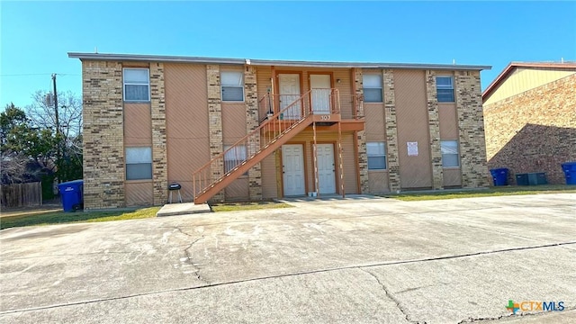 view of building exterior featuring stairs and central air condition unit