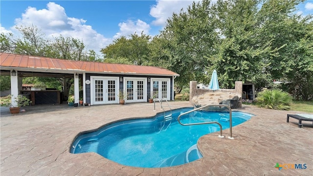 view of swimming pool with french doors, an outdoor structure, and a patio area