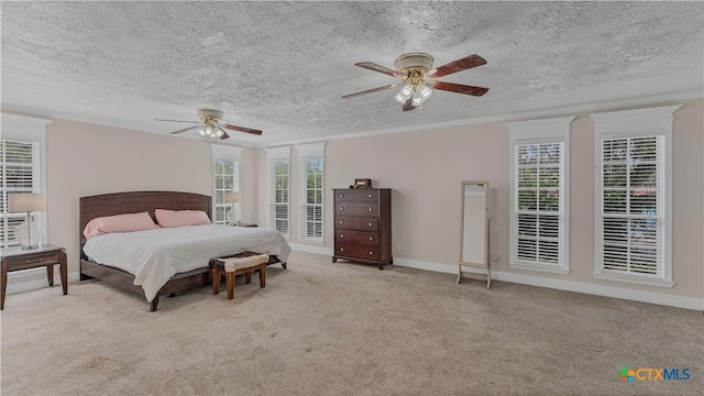 carpeted bedroom featuring ceiling fan, ornamental molding, and a textured ceiling